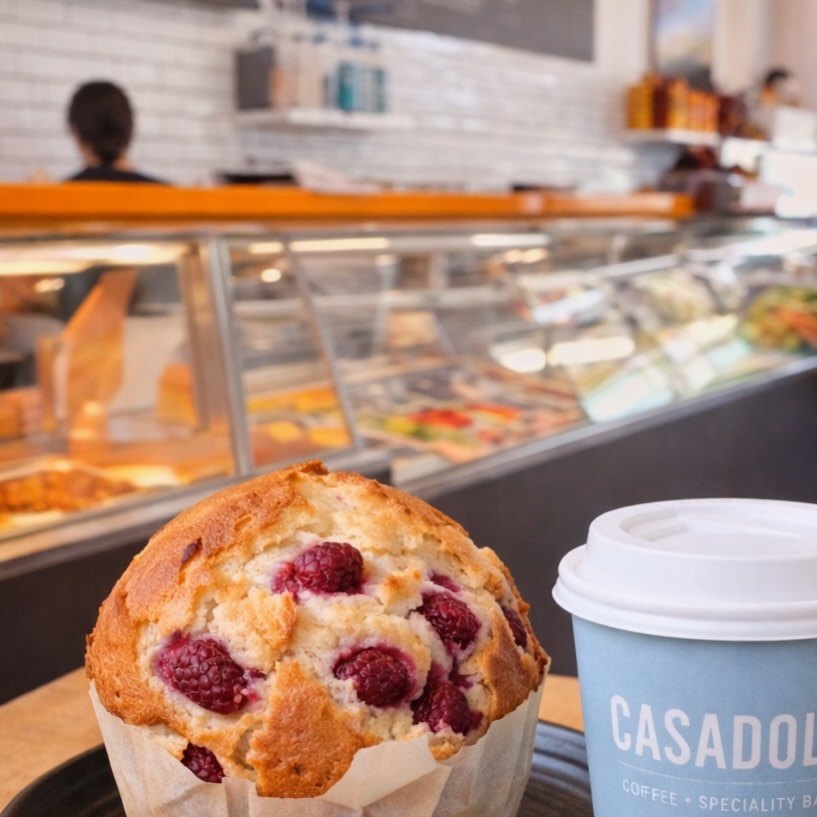 Raspberry muffin next to a Casadolcé cup
