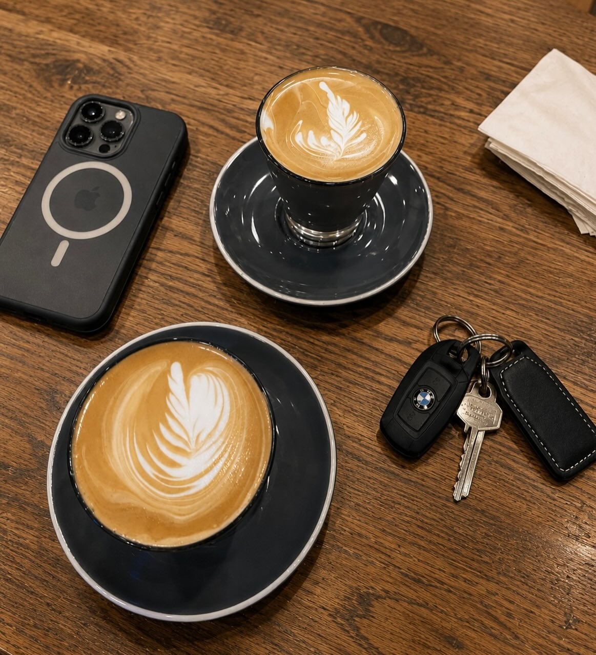 Two coffees with latte art on a timber table